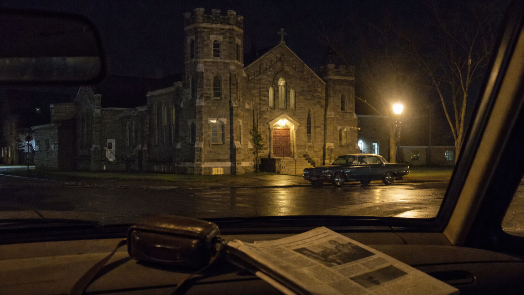 Rainy night outside a 1960s stone church, inspired by The Conjuring First Communion setting