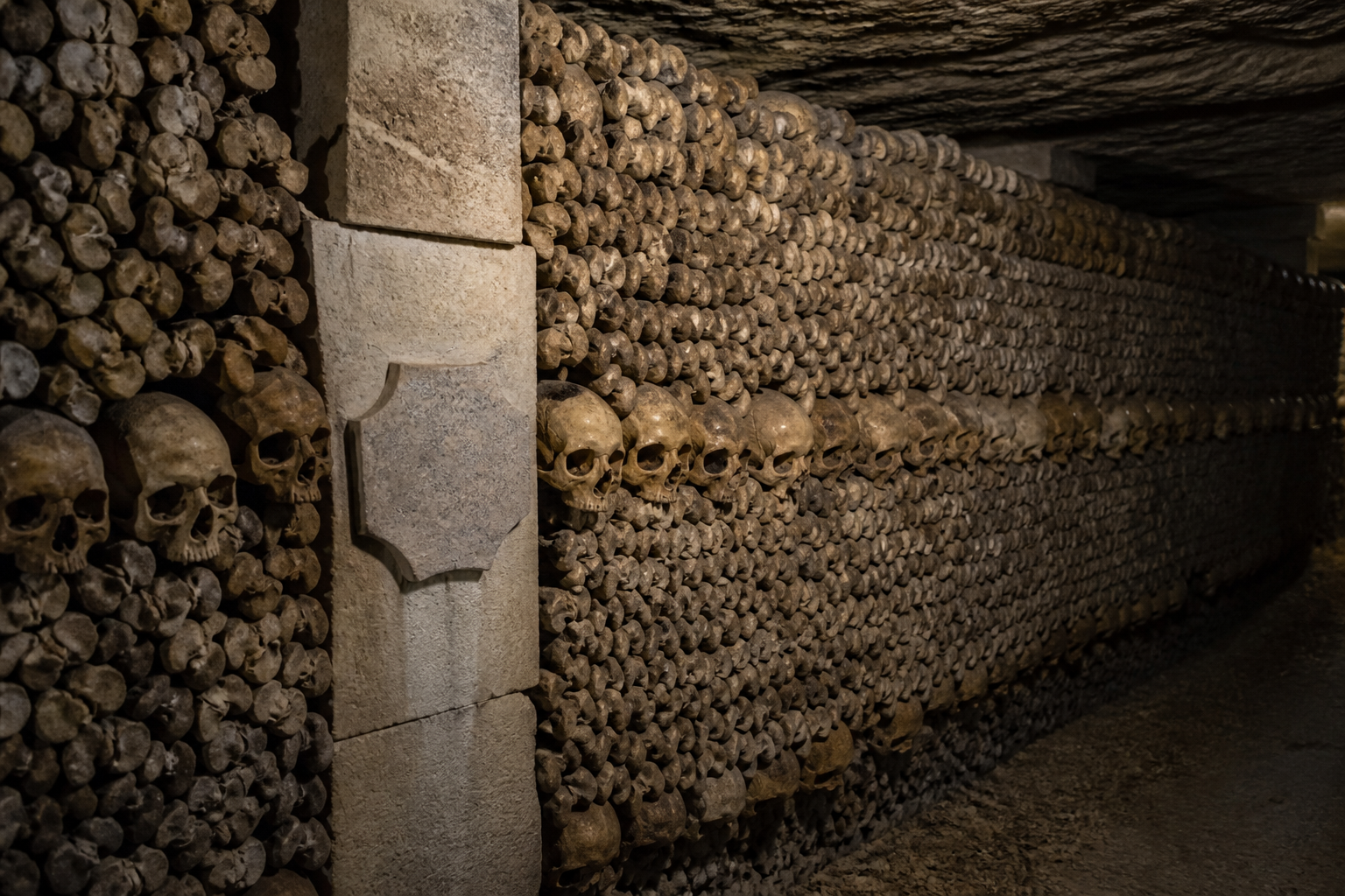 Respectful view of an arranged bone wall inside the Paris Catacombs ossuary