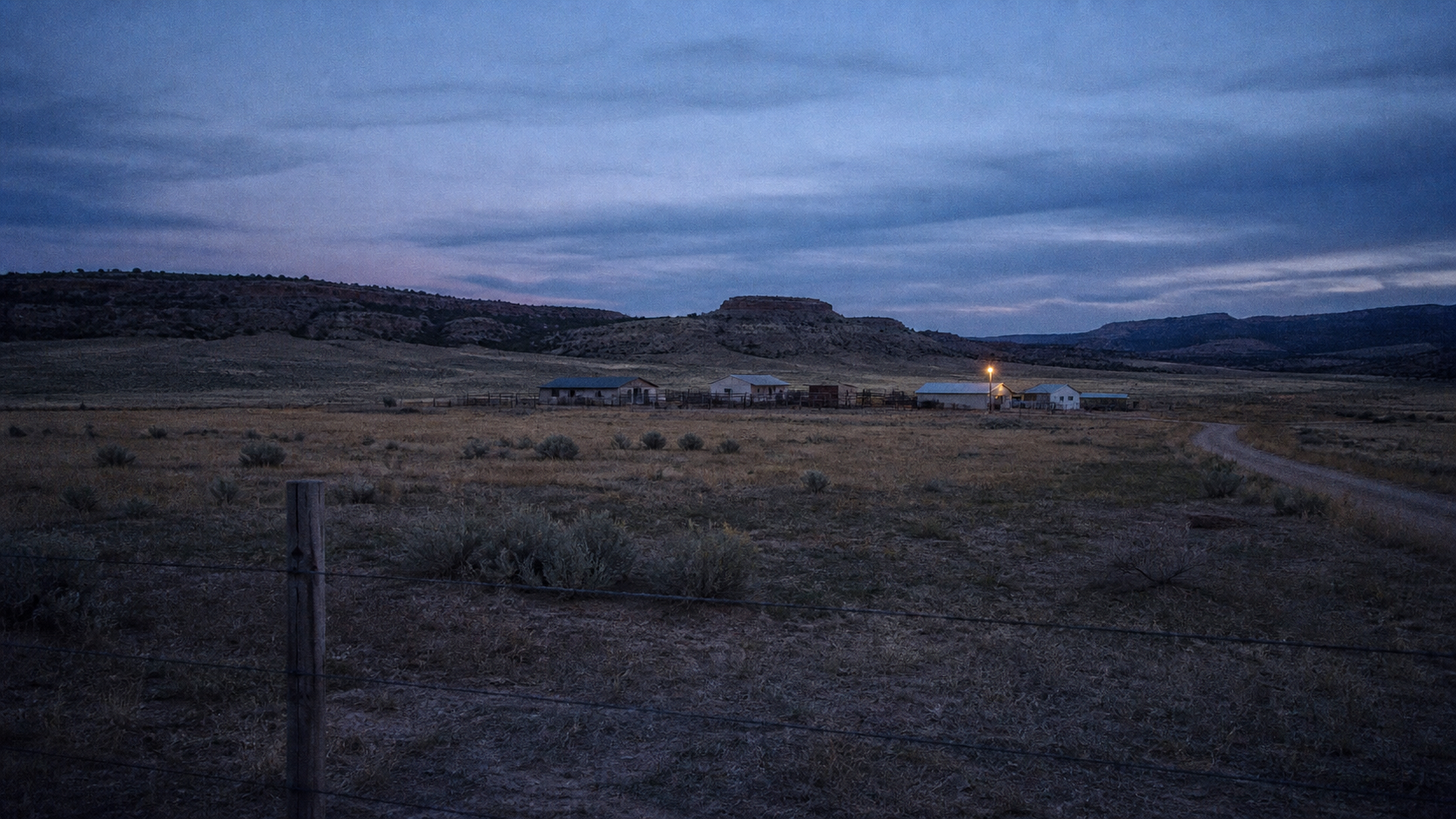 Skinwalker Ranch editorial artwork showing an ominous remote Utah ranch at blue hour