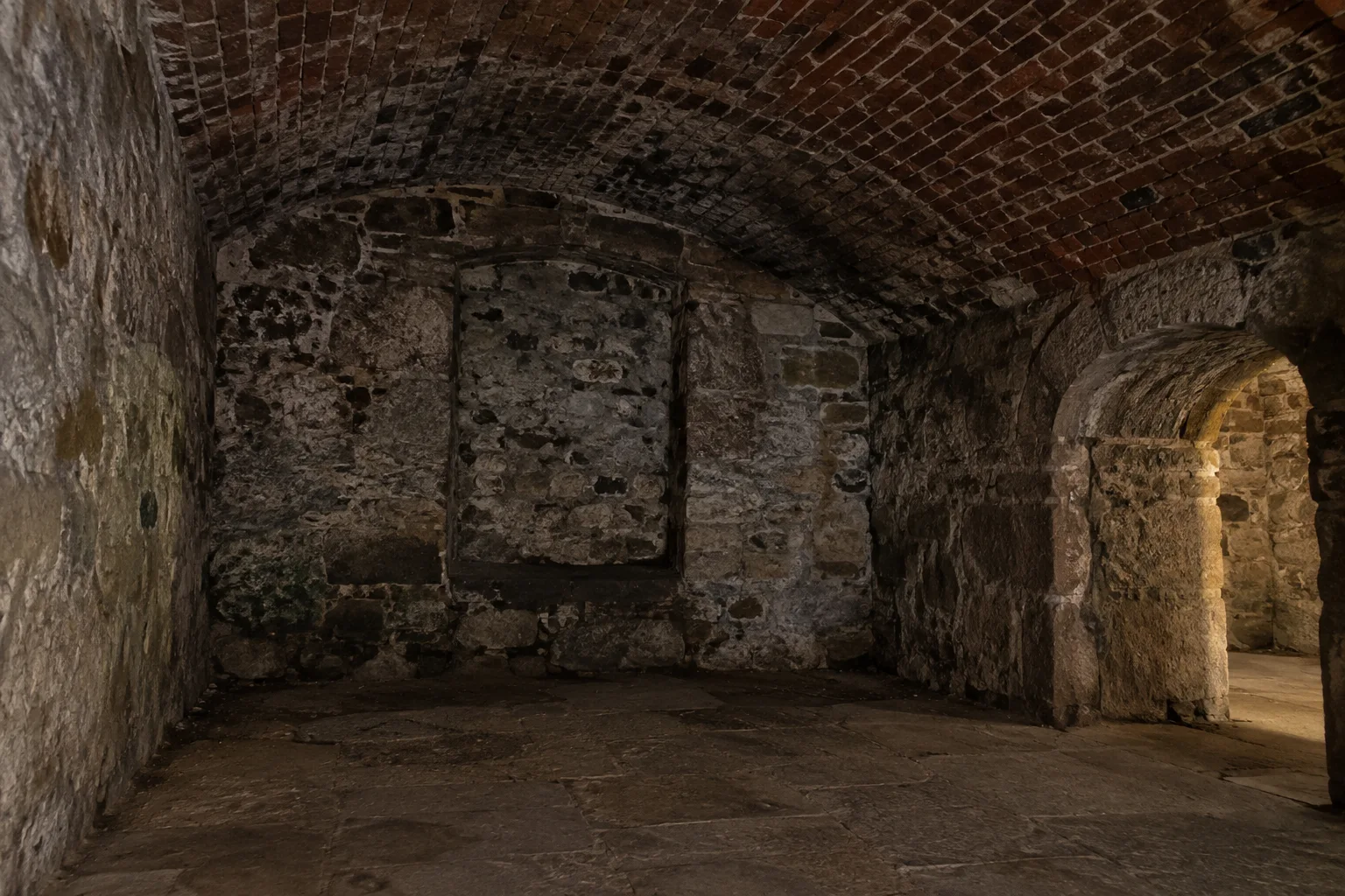 Empty Edinburgh Vaults inspired storage chamber with weathered stone walls
