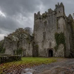 Leap Castle inspired Irish stone tower and ruined wing beneath an overcast sky