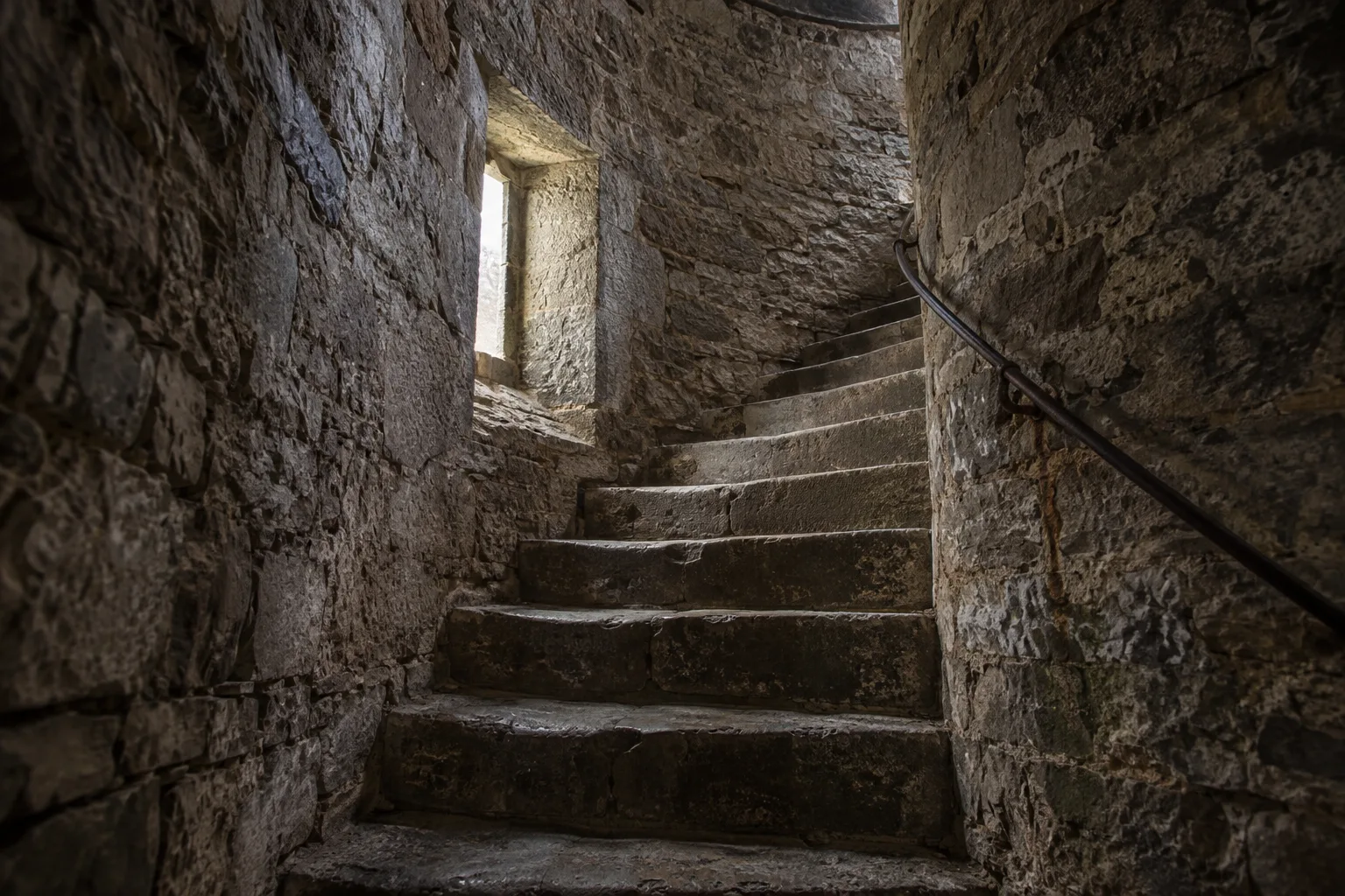 Leap Castle inspired spiral stone stair disappearing into an upper landing